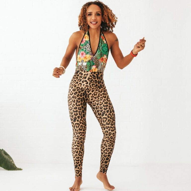 Melissa Neill smiling in a vibrant workout outfit with leopard-print leggings and a colorful top.